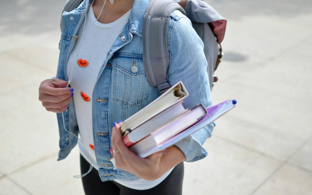Studentessa universitaria con libri e zaino per laptop