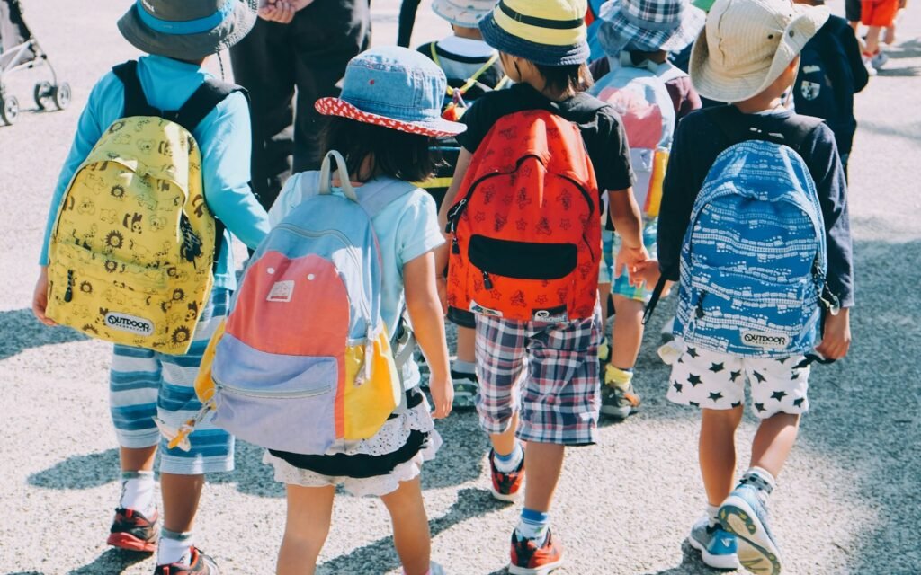 Bambini con zaini colorati per la scuola: immagine illustrativa per la guida allo zaino Stitch asilo